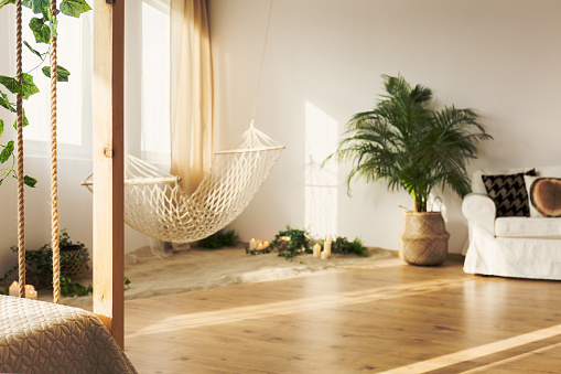 Natural hipster chillzone with sand and hammock in elegant stylish loft