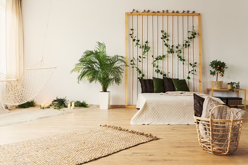 Stylish natural bedroom with simple hammock and plants