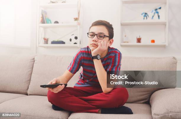 Bored Teenage Boy Watching Tv At Home Stock Photo - Download Image Now - Child, Teenager, Television Set