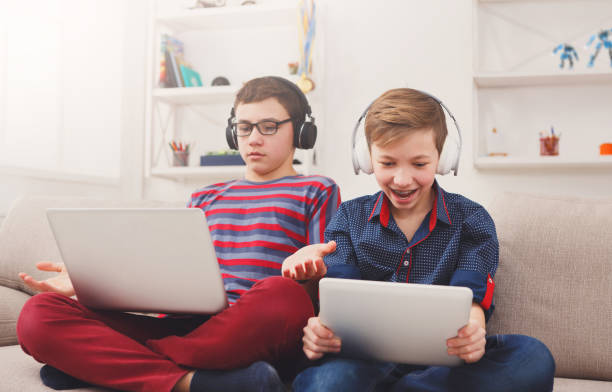 istock Two teenage boys using tablet on couch at home 828464260