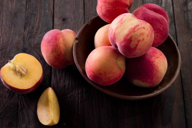 istock Ripe peaches in basket on wooden background 828465070