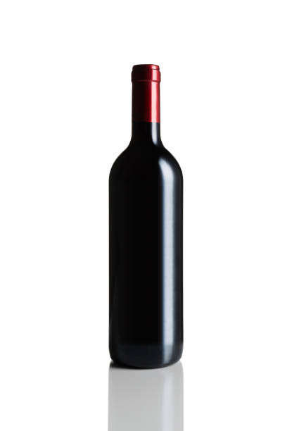 Bottle red wine on a old oak wooden table and coral orange background.