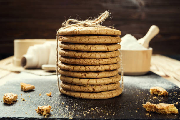 istock Biscuit sweet cookie background. Domestic stacked butter biscuit pattern concept,close up macro.Homemade cookies on wooden table.Cereal biscuits with the sesame,peanuts,sunflower and amaranth. 828468394