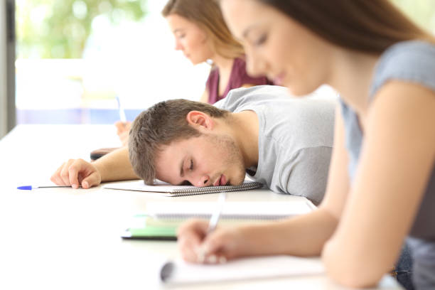 studente stanco che dorme in classe in classe - sleeping high school desk education foto e immagini stock