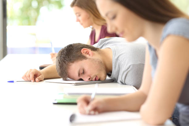 estudante cansada, dormindo em uma turma em sala de aula - sleeping high school desk education - fotografias e filmes do acervo