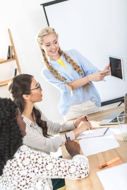istock young businesswomen working with tablet together 828469548