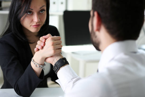 istock Woman and man in suit hold hands in wrestle 828469764