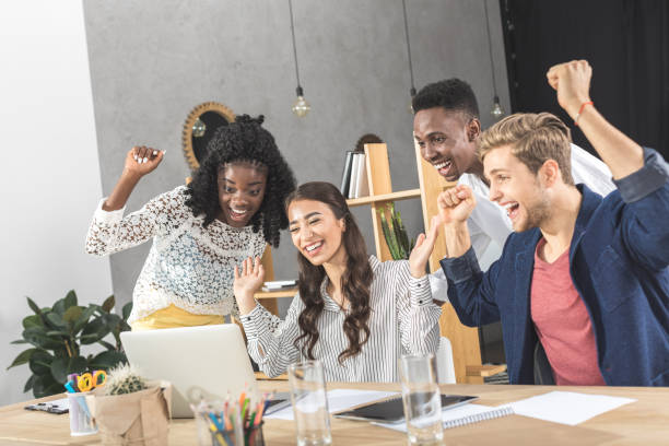 istock business people celebrating success at workplace with laptop 828472970