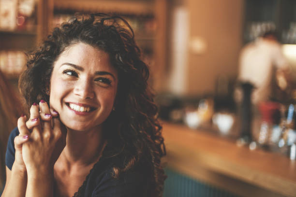 istock Smiling young woman in cafe 828473088