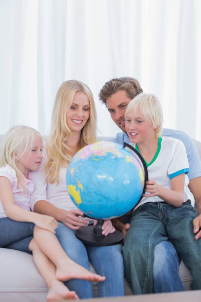 istock Happy family looking at globe on couch 828480900