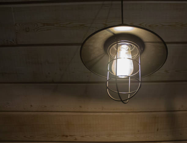 istock Old fashioned vintage lantern lamp burning with a soft glow light in an antique rustic country barn with aged wood wall and weathered wooden floor 828481750