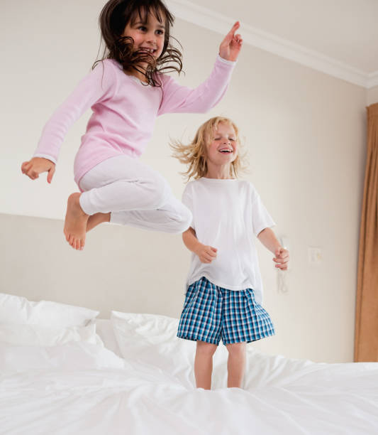 istock Portrait of playful siblings jumping 828482010