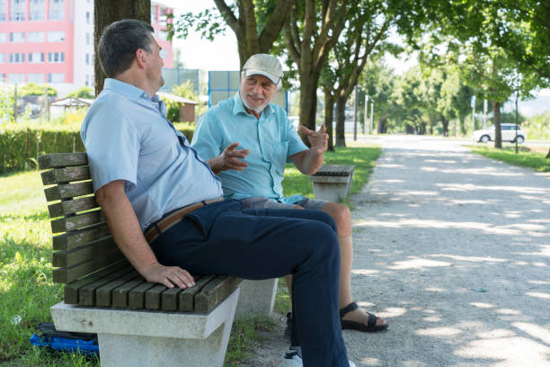 istock Two men laughing while sitting on bench on The Trail of Remembrance and Comradeship in Ljubljana, Slovenia 828484514