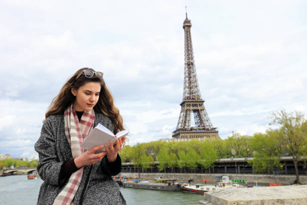 istock Woman reading book near Seine river 828485094