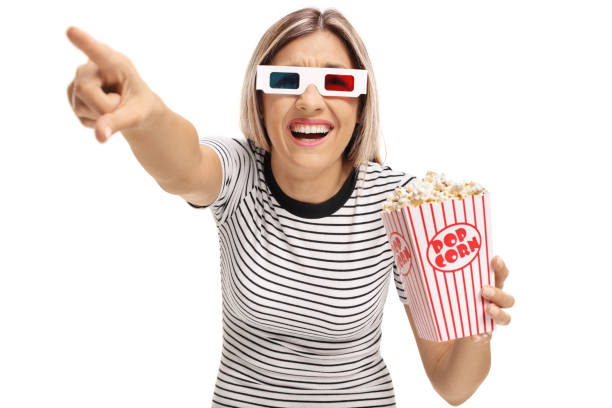 istock Young woman with 3D glasses and popcorn pointing and laughing 828488100