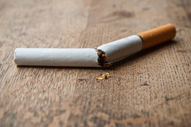 cigarette broken on wooden table background - cigarette smoking ashtray tobacco imagens e fotografias de stock