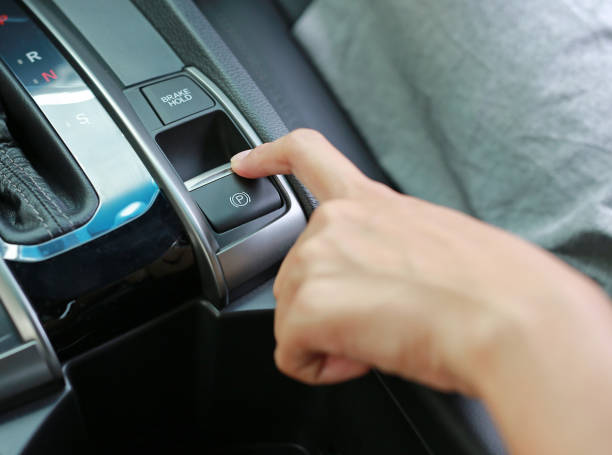 istock Hand pulling and pushing electric handbrake, Modern car interior. 828490818
