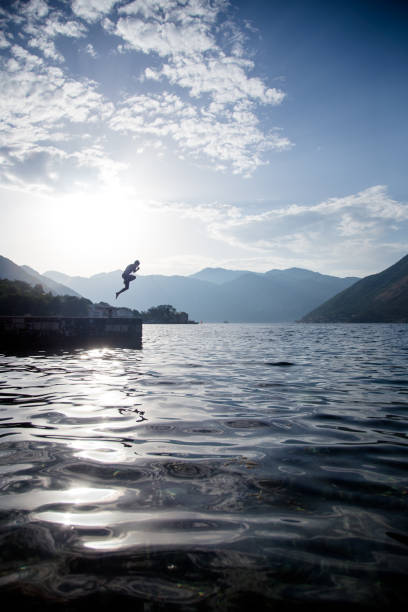 istock Young Man Jumping In Sea 828493498