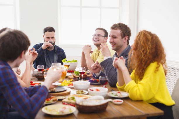istock Group of happy people at festive table dinner party 828501584
