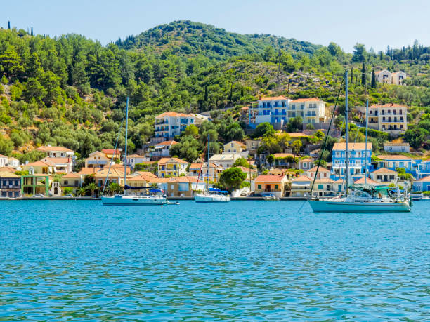 Yachts moored in Vithi, on the Greek island of  Ithaca. Yachts moored in the blue ionian sea in Vithi, on the island of Ithaca. Houses line the waterfront with wooded hills behind. woodland hills los angeles stock pictures, royalty-free photos & images