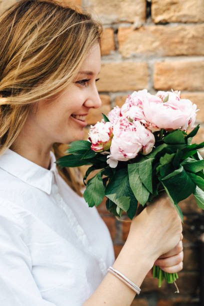 istock Blonde woman holding flowers 828503820