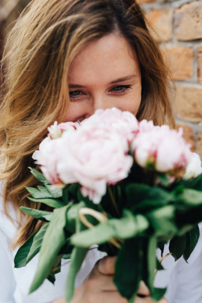 istock Blonde woman holding flowers 828503882