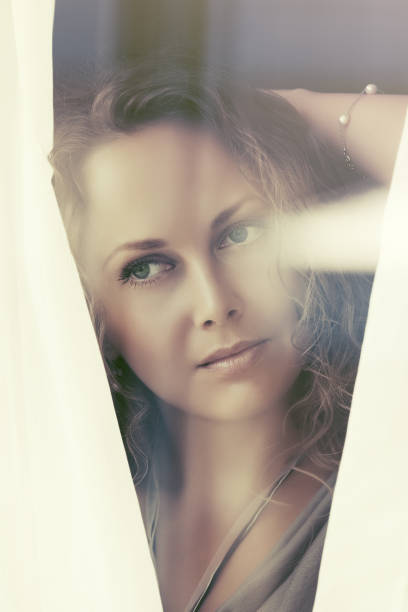 istock Sad beautiful woman looking out window 828504138