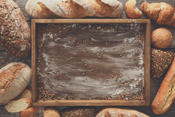 istock Bread bakery background. Brown and white wheat grain loaves comp 828504506