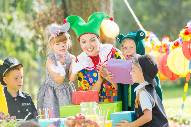 Clown and presents for kids Woman as a clown giving presents for kids on a party animator stock pictures, royalty-free photos & images