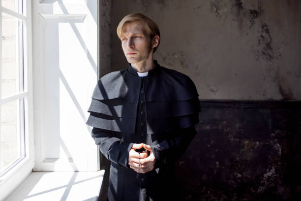 Portrait of handsome young catholic priest looking at you. Prayer stock photo