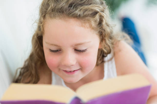 istock Girl reading a book on the sofa 828510342