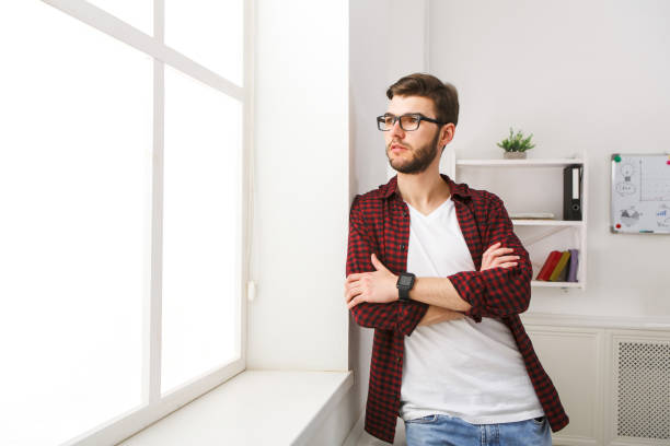 istock Confident young businessman at office near window 828514062