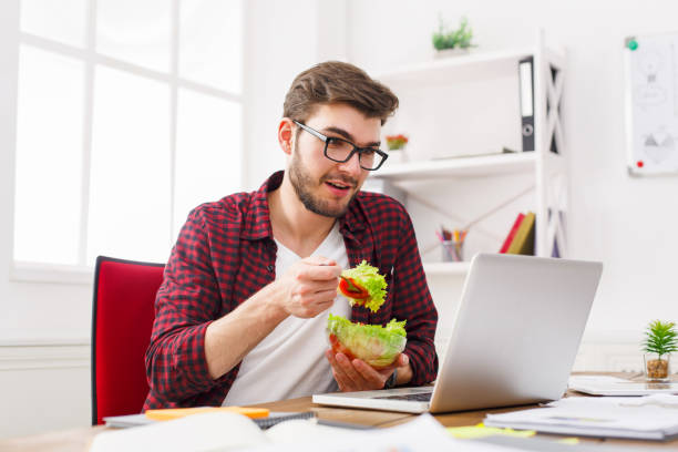 istock Man has healthy business lunch in modern office interior 828514402