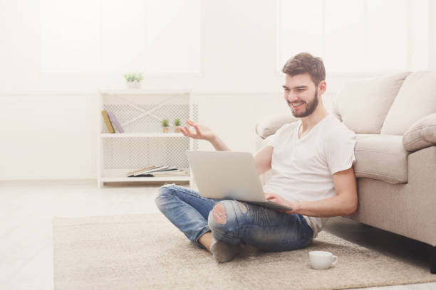 istock Smiling man with laptop indoors 828515410