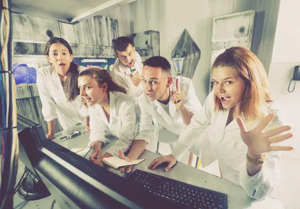 Photo of Adults laughing and grimacing in quest room-laboratory