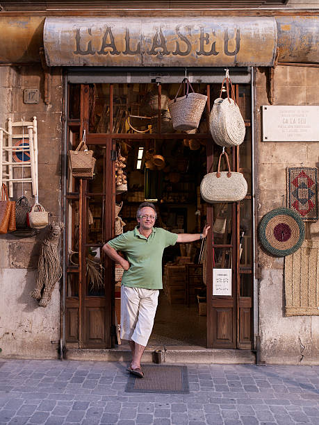 shop owner stands outside his shop - palma majorca stok fotoğraflar ve resimler