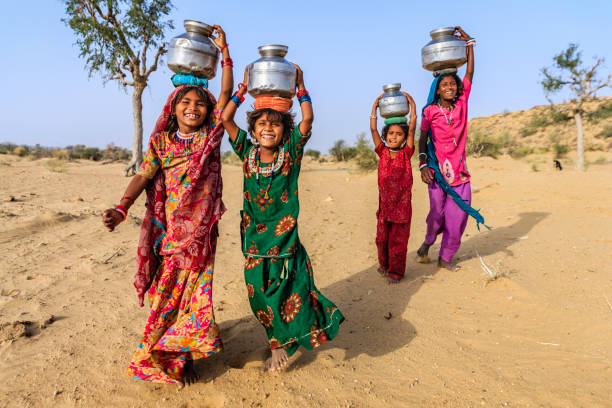 indische mädchen tragen von wasser auf den kopf gut - poverty india child little girls stock-fotos und bilder