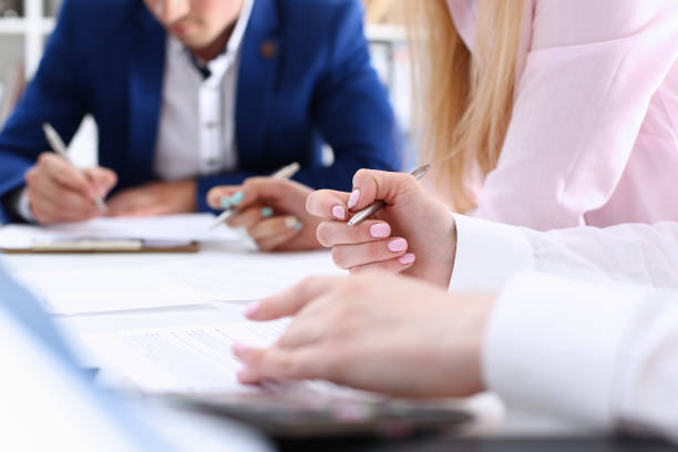 istock Group of people hold silver pen ready to make note 828523574
