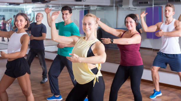 istock Adult people learning zumba steps 828523868