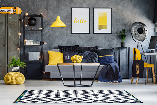 Optimistic teenager's room with gray wall, furniture and yellow accents