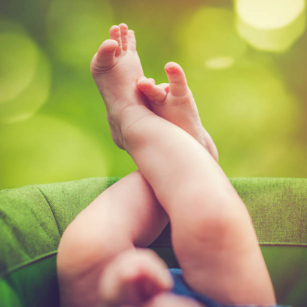 Cute baby boy's feet in carriage in summer