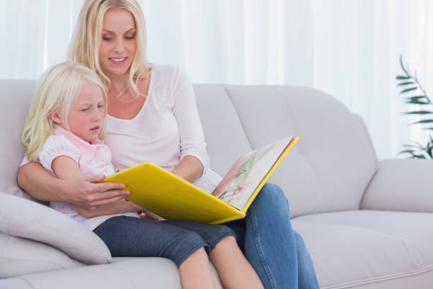 istock Mother and daughter sitting on couch 828537724