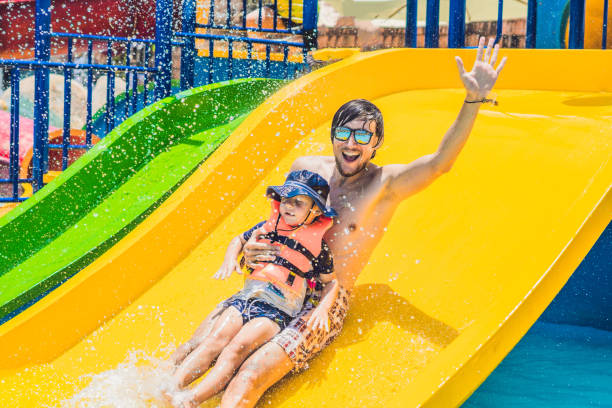 istock Father and son on a water slide in the water park 828538574