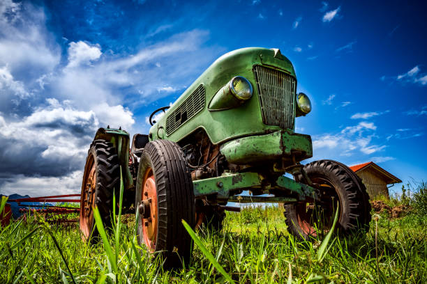 alter traktor in den almwiesen - landwirtschaftliches gerät stock-fotos und bilder