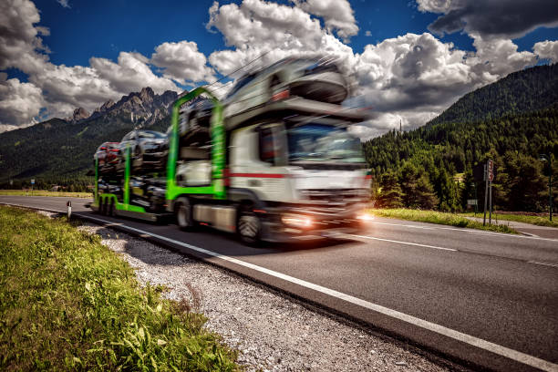 camion remorque transporte les nouveaux manèges de voitures sur l’autoroute - auto carrier photos et images de collection