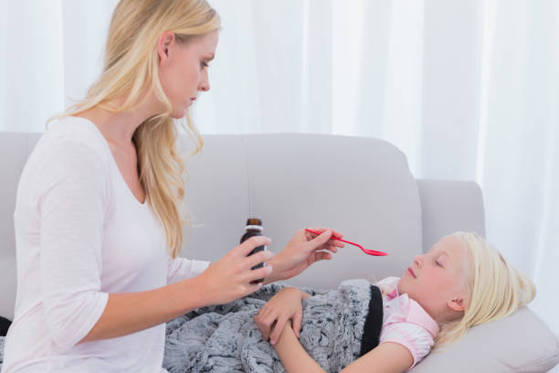 istock Concerned mother giving her daughter medicine 828553504