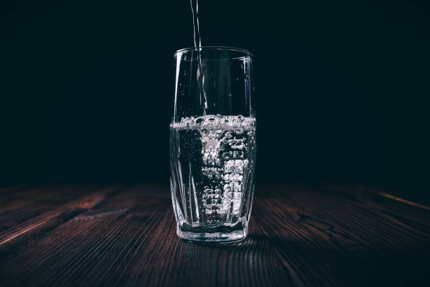 istock Water poured into a faceted glass on a black background 828571344