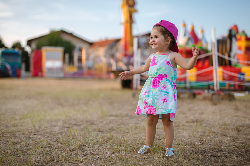 A baby girl of 2 years is the first time at the fair. She is having fun.