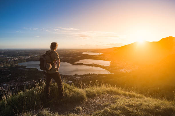istock Hiker watching sunset on top of mountain 828610544