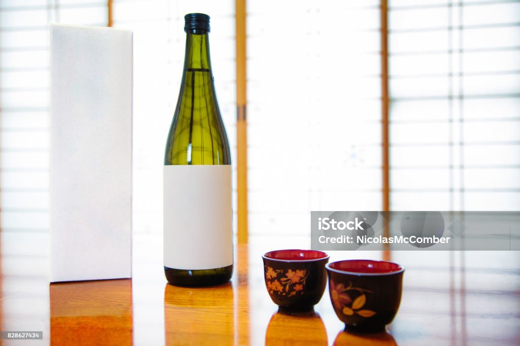 Japan blank Sake bottle and box with lackered cups in front of paper doors Saki Stock Photo